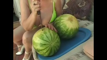 Meaty blonde with huge jubblies is making blowjob through piece of watermelon